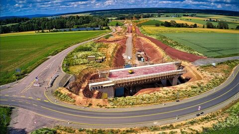 Überbauherstellung für das BW 3, ÜF der K 72 mit Umfahrung für die Kreisstraße und Blick in Richtung Bauwerk 5 (WiWeg Hasselhof) und Landesgrenze NRW. Stand Mai 2020. Landschaftaufnahme einer grünen Landschaft im Sonnenschein mit Straßenarbeiten im Vordergrund