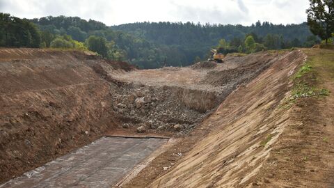 Foto des Bauplatzes - Dort, wo das ehemaligen Steinbruchgelände einst mit Erdreich aufgefüllt war, wird mit besonderen Gründungsmaßnahmen für die Standfestigkeit der zukünftigen Straße gesorgt.