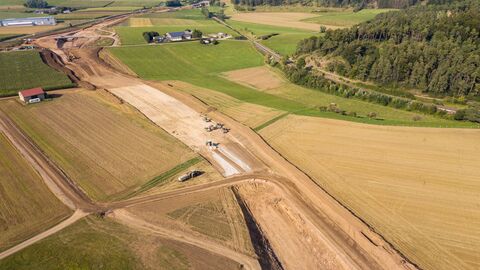 Luftaufnahme - In den Bereichen der Trasse, die etwas heller erscheinen, wurde bereits eine sogenannte Bodenverbesserung vorgenommen. Hier fräst ein Spezialgerät ein Kalkzementgemisch in den zu stabilisierenden Boden ein, auf dem dann die Straße aufgebaut wird.
