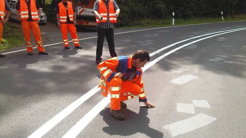 Unfallanalysen erhöhen Verkehrssicherheit Experte der Unfallanalyse begutachtet die Fahrbahnoberfläche.
