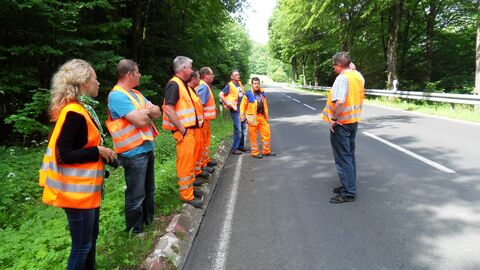 Teilnehmer der Unfallkommission besprechen sich an einer Straße.