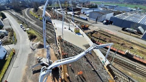 Bauarbeiten an einer Eisenbahnbrücke mit zwei Krähnen.