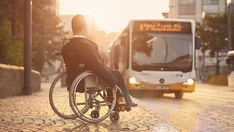 Mann im Rollstuhl wartet auf den Bus