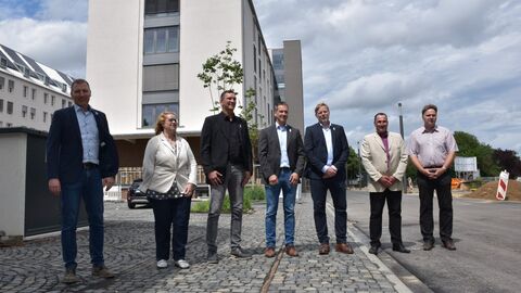 Ende Juni beziehen 207 Mitarbeitende von Hessen Mobil ihre neuen Büros am Standort Kassel. Die modernen Büros mit Altbauflair enstanden in einem ehemaligen Lagerhaus, dem sogenannten Magazinhof. Hessen Mobil Mitarbeitende stehen vor den neuen Bürogebäuden.