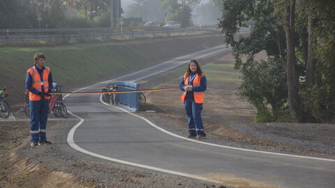 Verkehrsfreigabe, Geh- und Radweg, Jesbeg-Oberurff 7 Die neu gebaute Strecke wartet auf die erte Befahrung. Zwei Jugendliche halten ein Stoffband