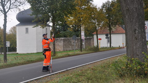 Ein Baumkontrolleur von Hessen Mobil macht ein Foto eines Baums um seinen Zustand zu dokumentieren