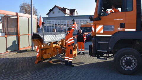 Ein Schneepflug wird an einen LKW montiert