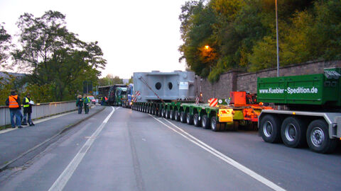 Großraum-Schwertransport stehtr vor einer Unterführung und wird millimetergenau hindurchgelotst