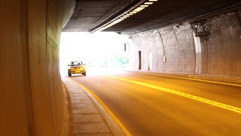 Ein Fahrzeug fährt in einen Tunnel - vom inneren des Tunnels aus fotografiert.