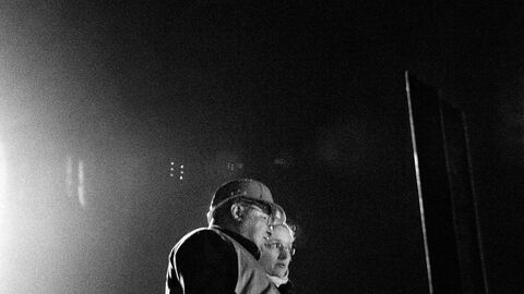 Personen mit Helm beobachten den Brückenabbruch