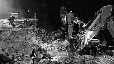 Ein Arbeiter ist neben schwerem Gerät beim Abbruch zu sehen