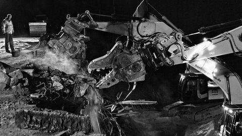 Ein Arbeiter beobachtet die Abbrucharbeiten einer großen Maschine