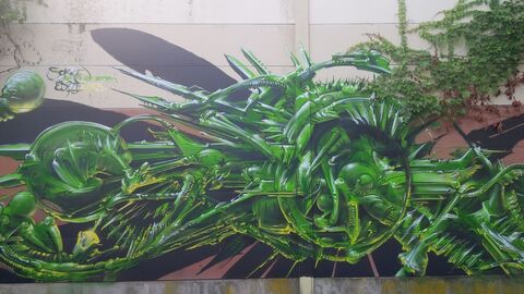 Grüne futuristische Elemente gestaltet als Graffiti auf einer Betonmauer als Teil des Kunstprojektes Bunt statt Grau