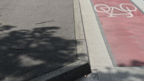 Ein farblich abgesetzter Radweg mit einem Radfahrpiktogramm.