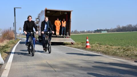 Staatssekretär deutschendorf und Hessen Mobil-Präsident heiko Durth testen auf zwei Fahrrädern fahrend die Funktionsweise der Zählstelle