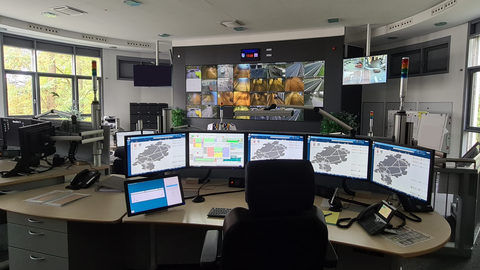 Dr Kontrollraum der Tunnelleitzentrale mit großer Kontrollleinwand und mehreren Arbeitsplätzen.