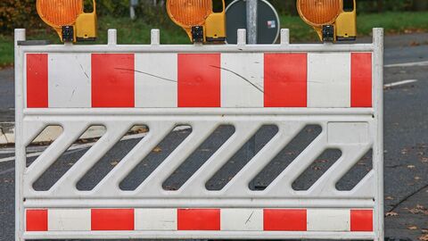 Rot-weiße Absperrbake mit gelben Baustellenleuchten Rot-weiße Absperrbake mit gelben Baustellenleuchten