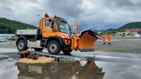 Ein orangener Schneepflug überfährt die Rampe