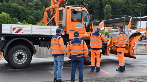 Trainingstag Schneepflugmeisterschaft 19 Meherer Straßenwärter diskutieren untereinander und gben dem Unimogfahrer Tipps
