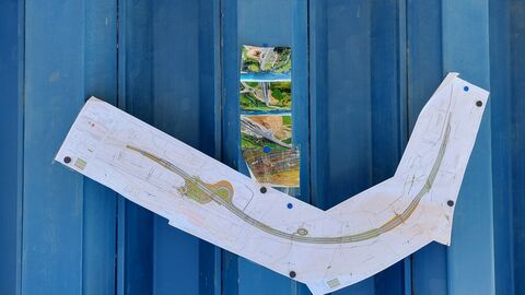 Ausgedruckter Übersichtsplan an einer blauen Baustellenwand 