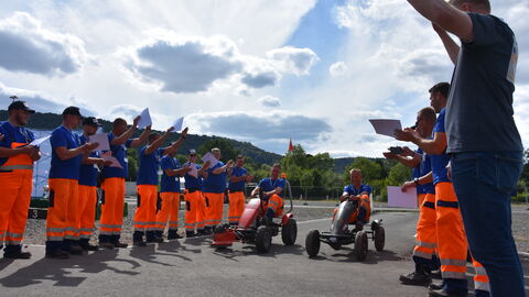 3. Hessische Schneepflugmeisterschaft Finale 34 das Gewinnerteam fährt mit Kettcars durch ein Spalier der Teilnehmenden