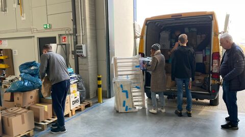 Transporter wird ausgeladen von Männern in Flüchtlingsunterkunft Transporter wird ausgeladen von Männern in Flüchtlingsunterkunft