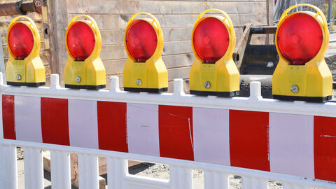 Baustellenabsperrung mit aufgesetzten Warnlampen rot-weiße Baustellenabsperrung mit aufgesetzten Warnlampen