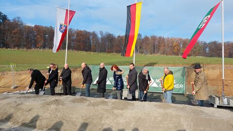 Spatenstich zur Ortumgehung Hahn - die Ehrengäste sind aufgereiht, im Hintergrund wehen Fahnen
