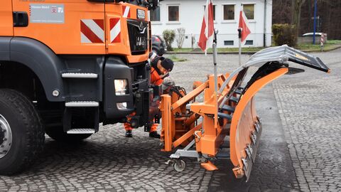 Pressetermin Auftakt Winterdienstsaison 2022/2023 - 15 Ein Mitarbeiter überpüft im Knien die Verbindung des Schneepflugs mit dem LKW