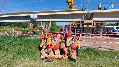 K 147 - Ballett der Riesenkräne an der Fulda Ballett der Riesenkräne an der Fulda: In Millimeterarbeit werden neun Brückenteile der K 147 an die passende Position gebracht. Die Kiebitze des Kindergarten Röhrenfurth haben genau hingeschaut. Seit Oktober verbindet der Ersatzneubau der Fuldabrücke wieder den Ort Wagenfurt mit der B 83.