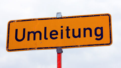 gelbes Umleitungsschild mit schwarzer Schrift 