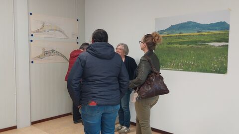 Besucher/innen der Ausstellung vor einem Plakat