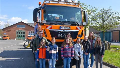 Gruppenbild der Teilnehmenden am Girls-Day vor einem orangenen Einsatzfahrzeug von Hessen Mobil