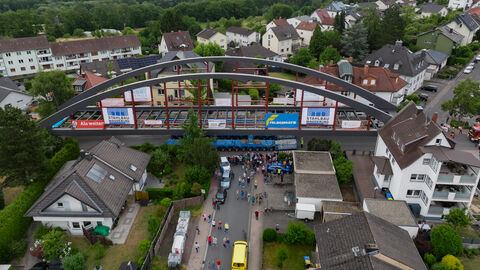 Das Brückenteil aus Stahl rollt langsam zwischen den Häusern hindurch