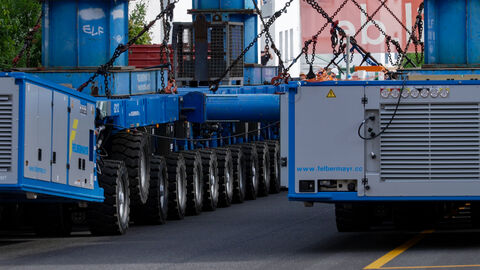 Das Brückenteil aus Stahl auf dem Schwertransport mit vielen kleinen Rollen