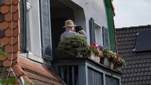Anwohner schauen vom Balkon aus zu
