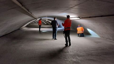 Bauwerksprüfung Lohbergtunnel 2023 - 07 Mehrere Personen im halbrunden Stollen über der Tunneldecke