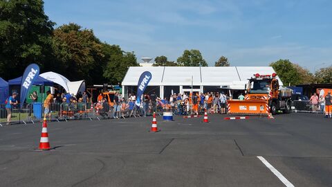 Deutsche Meisterschaft im Schneepflugfahren 2023 - 7 Orangefarbener Unimog mit Schneepflug im Geschicklichkeitsparcours