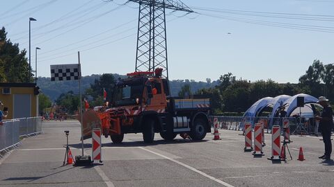 Deutsche Meisterschaft im Schneepflugfahren 2023 - 9 Orangefarbener Unimog mit Schneepflug im Geschicklichkeitsparcours