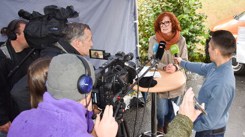 Kathrin Brückner gibt ein Interview umringt von Kameras und Mikrofonen
