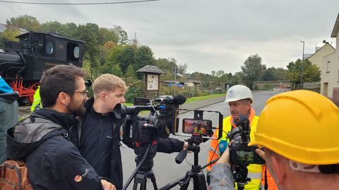 Kamerateams interviewen den Sprengmeister