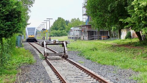 Bahnschiene mit Prellbock im Vordergrund - Zug im Hintergrund 