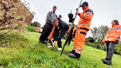 Azubis helfen beim Vermessen mit einem Vermessungsgerät