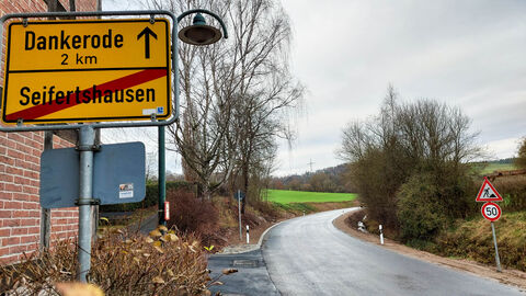 Ortsschild Seifertshausen im Vordergrund, sanierte Landesstraße im Hintergrund