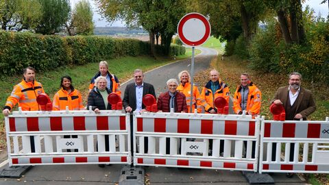 Die Beteiligten freuen sich hinter der neu errichteten Absperrung über den Beginn der Arbeiten auf der K38